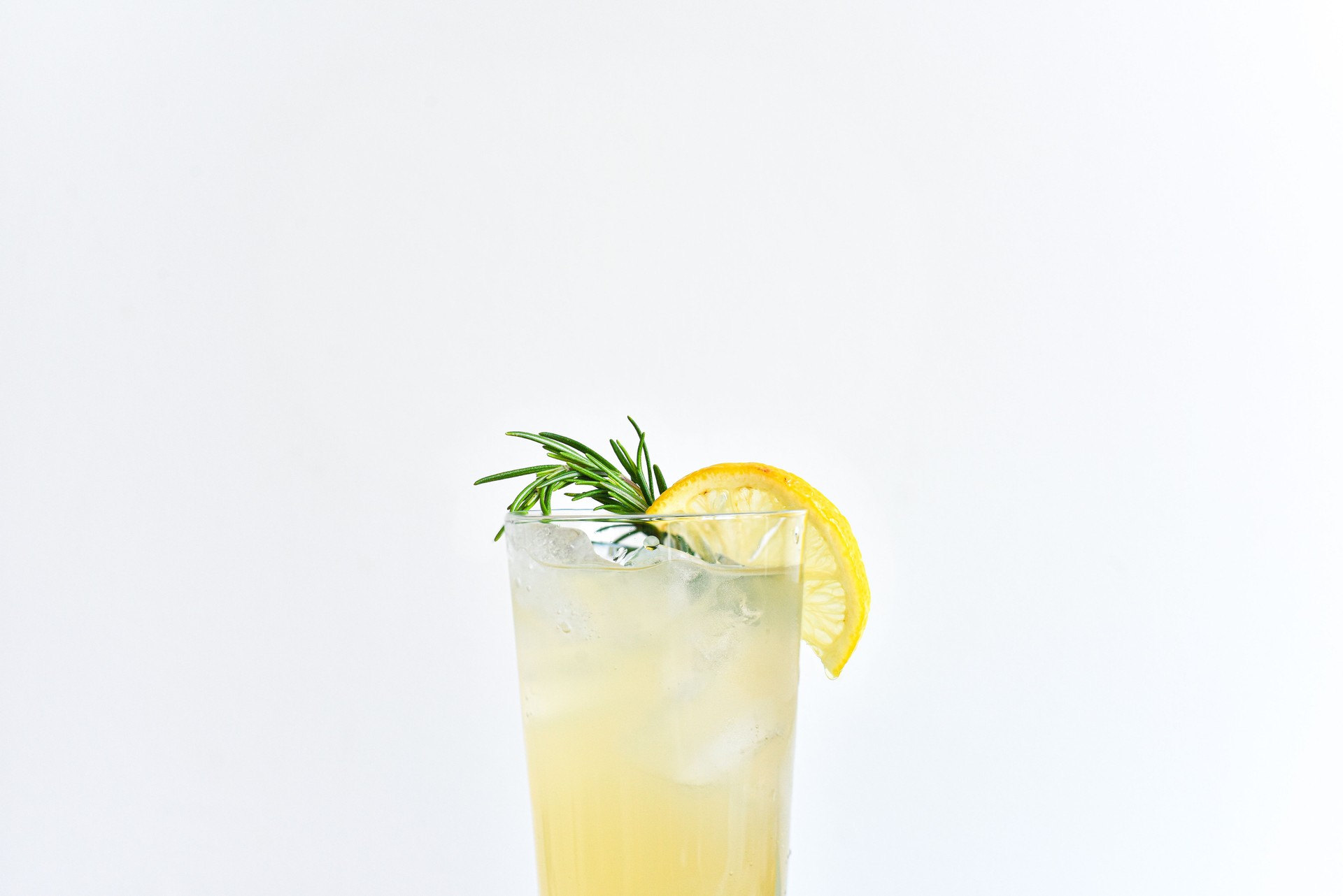 Drink Filled to Top of Glass with Lemon and Rosemary Accents